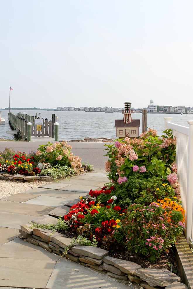 Maritimer Vorgarten im Sommer mit direkter Sonneneinstrahlung, Natursteinplatten und Blumenbeet in Philadelphia