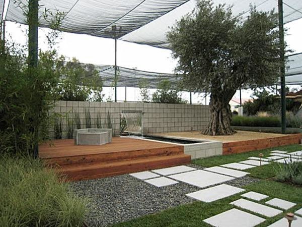 На фото: садовый фонтан среднего размера на заднем дворе в стиле модернизм с полуденной тенью и настилом