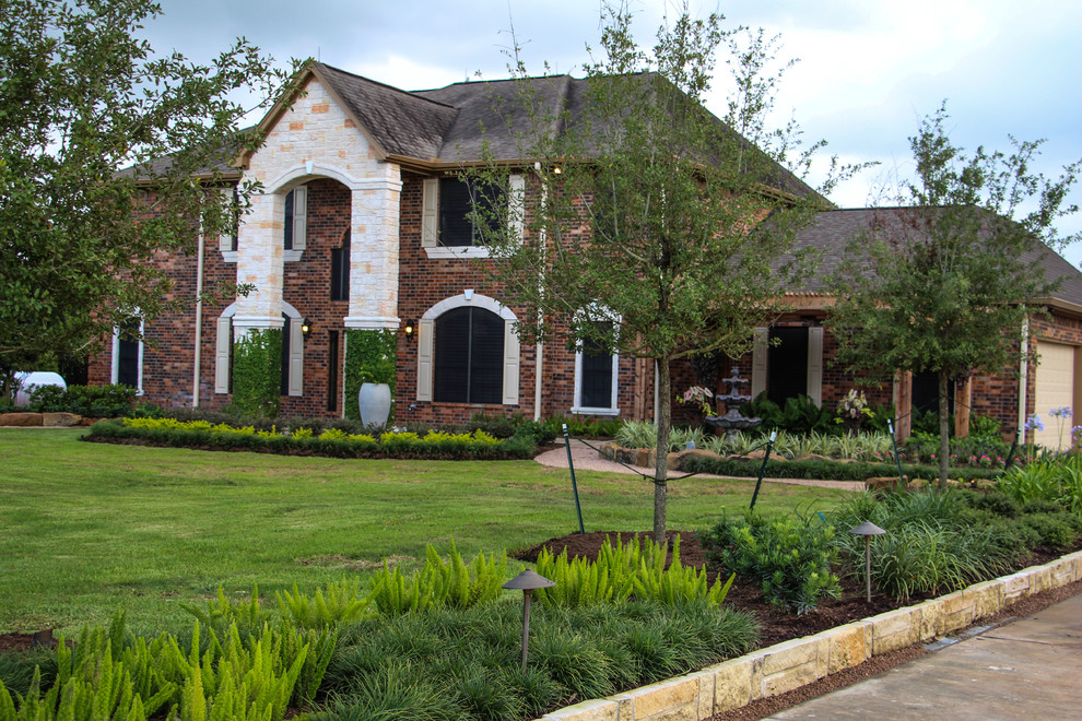 Photo of a huge traditional full sun front yard landscaping in Houston.