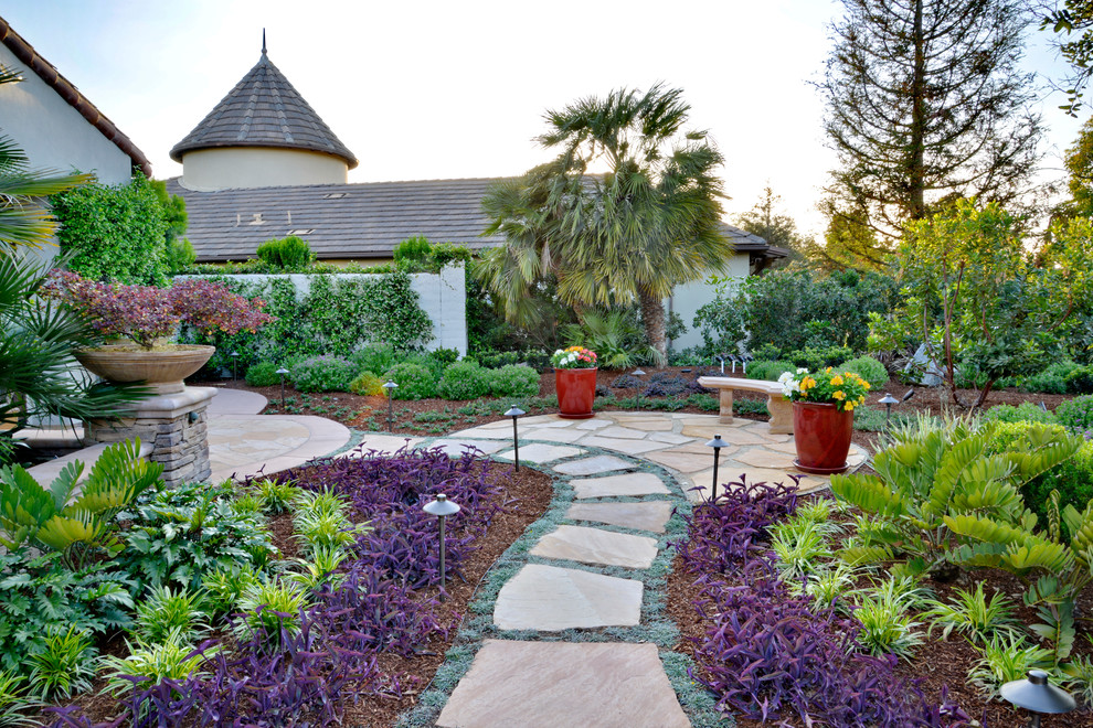 Expansive mediterranean back formal partial sun garden for summer in San Diego with a garden path and natural stone paving.