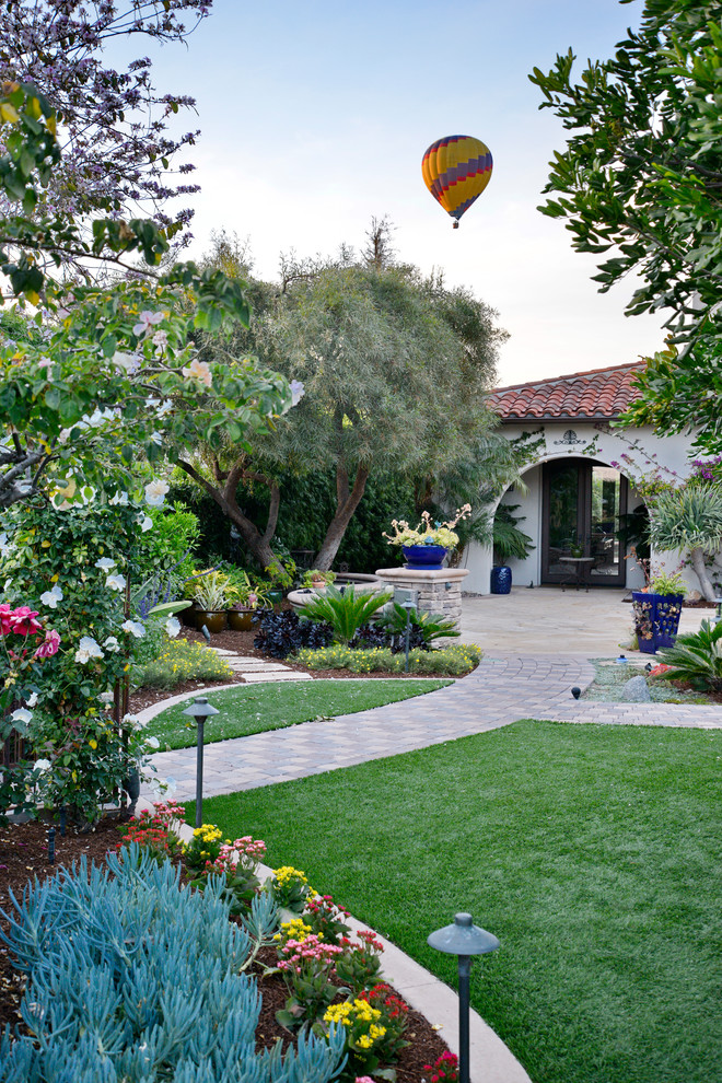 Immagine di un ampio giardino formale mediterraneo esposto a mezz'ombra davanti casa in estate con un ingresso o sentiero e pavimentazioni in cemento