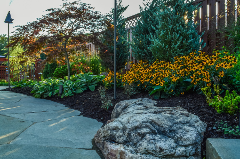 Idee per un grande giardino american style esposto in pieno sole dietro casa in primavera con pavimentazioni in pietra naturale