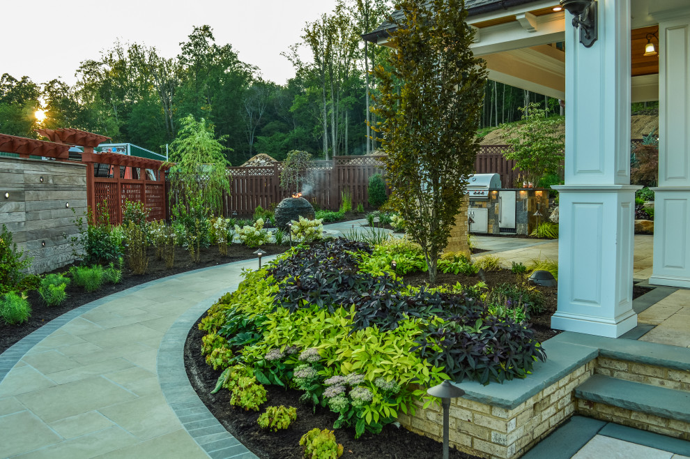 Idee per un grande giardino stile americano esposto in pieno sole dietro casa in primavera con pavimentazioni in pietra naturale