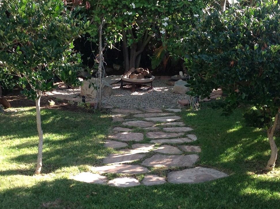 Photo of a medium sized rustic back xeriscape fully shaded garden in San Diego with a fire feature and gravel.