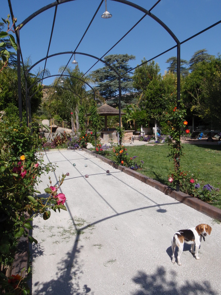Photo of a large world-inspired back full sun garden for summer in Los Angeles with an outdoor sport court and a garden path.