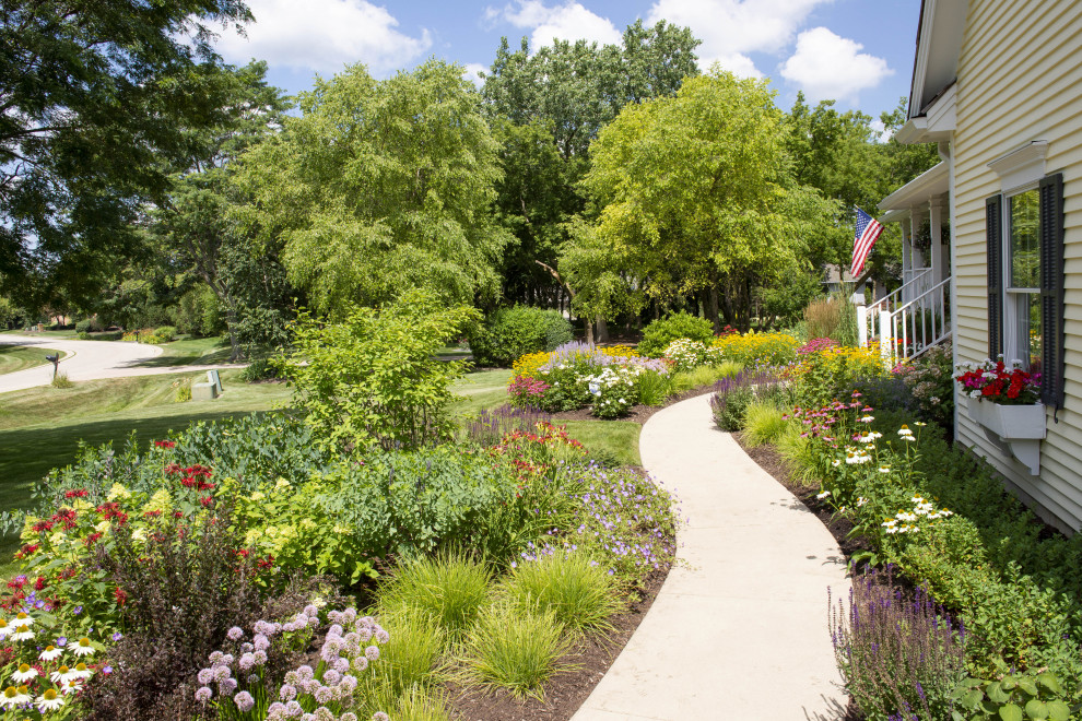 Foto di un grande giardino classico esposto in pieno sole davanti casa in estate