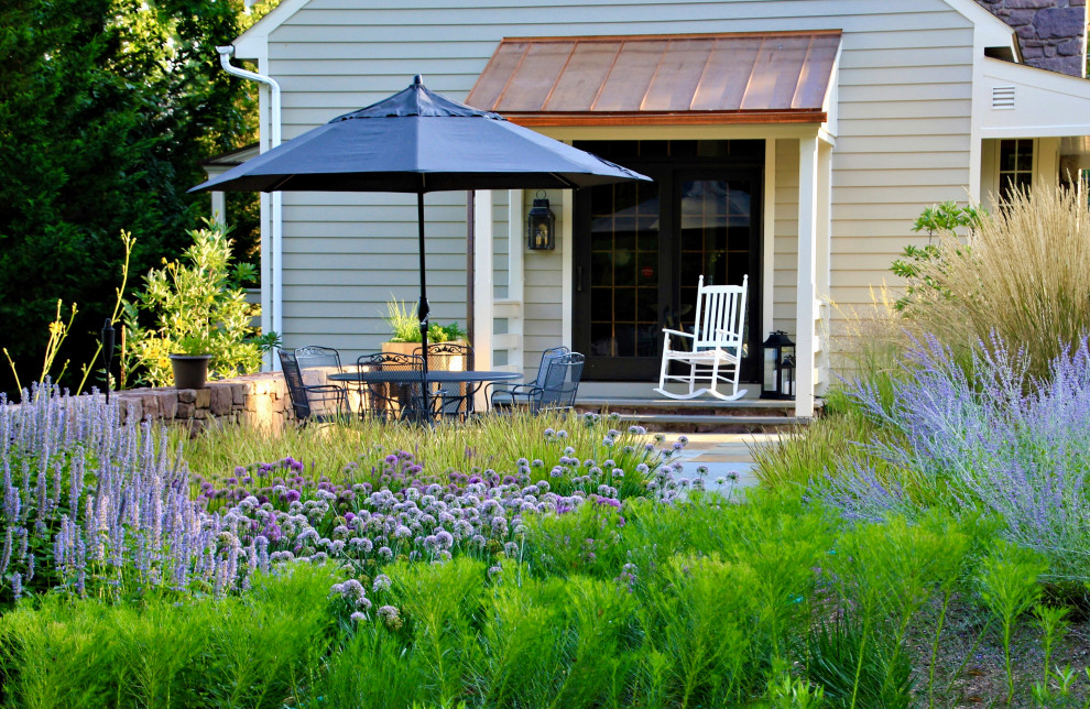 Foto de jardín de secano campestre de tamaño medio en patio trasero con muro de contención, exposición parcial al sol y adoquines de piedra natural