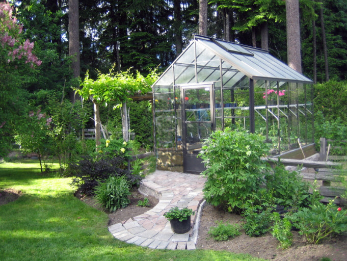 Foto di un piccolo giardino formale tradizionale esposto a mezz'ombra dietro casa in primavera con un giardino in vaso e pavimentazioni in mattoni