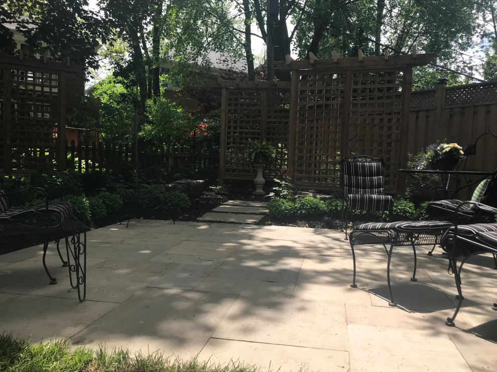Imagen de jardín de tamaño medio en verano en patio trasero con jardín francés, privacidad, exposición reducida al sol y adoquines de piedra natural