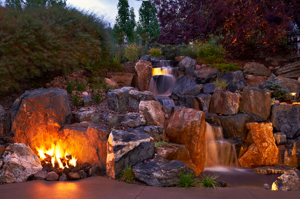Inspiration for a mid-sized rustic partial sun backyard stone water fountain landscape in Denver for summer.