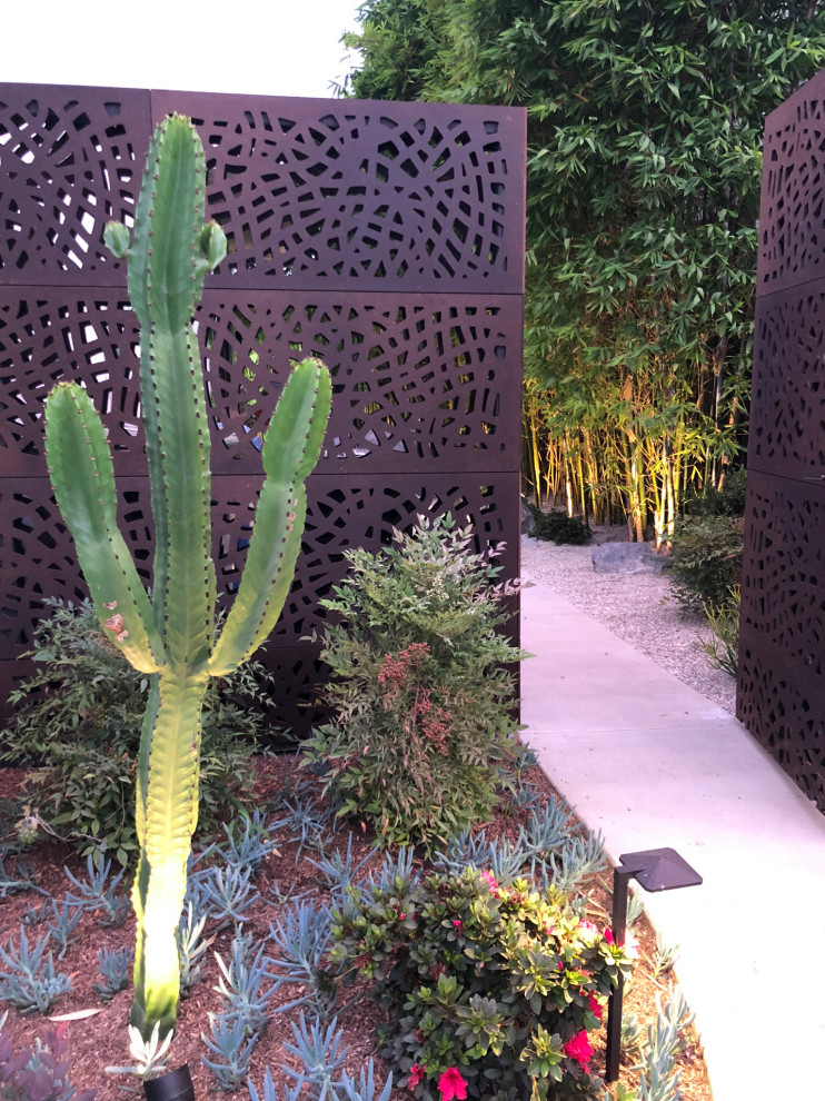 Ispirazione per un giardino xeriscape moderno esposto a mezz'ombra di medie dimensioni e davanti casa con cancello e ghiaia