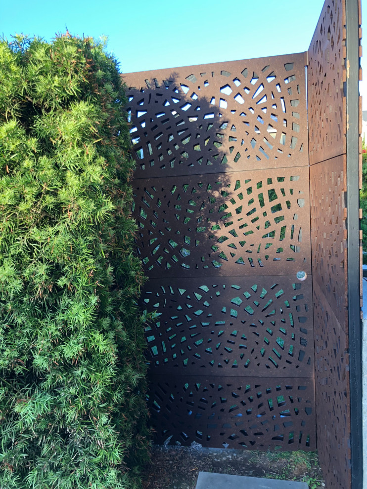 Immagine di un giardino xeriscape minimalista esposto a mezz'ombra di medie dimensioni e davanti casa con cancello e ghiaia