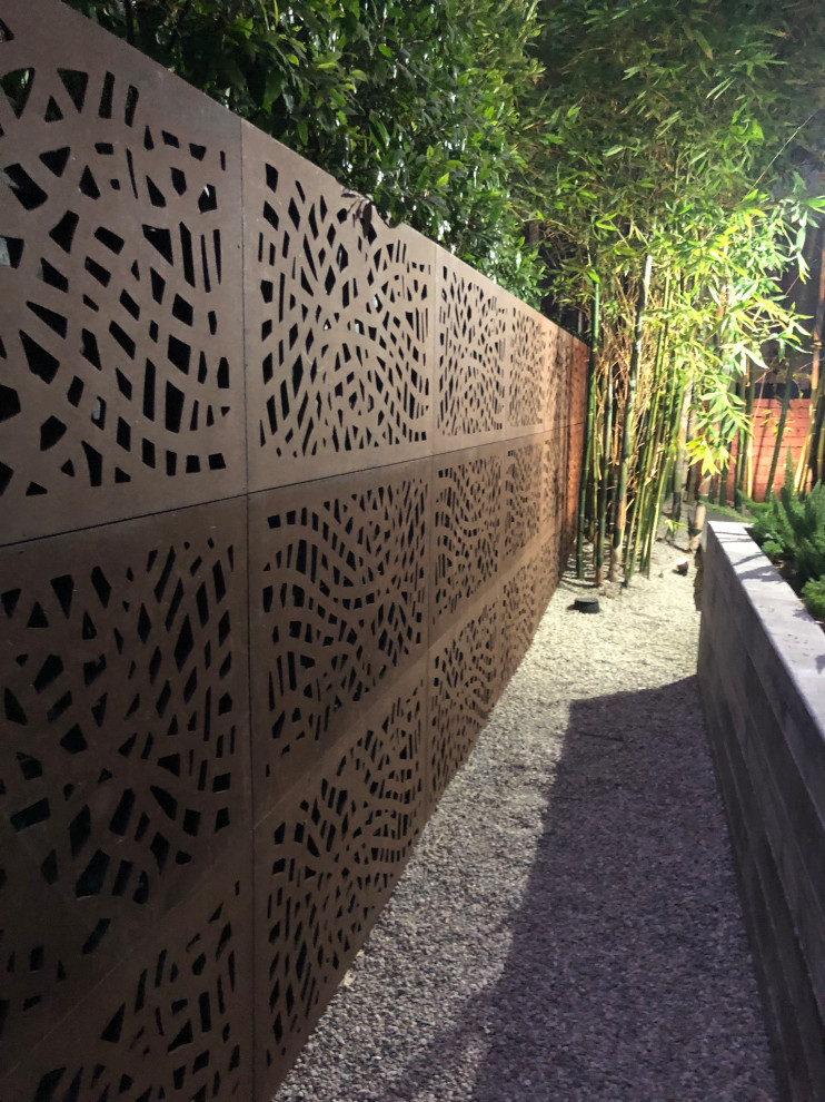 На фото: засухоустойчивый сад среднего размера на переднем дворе в стиле модернизм с воротами, полуденной тенью и покрытием из гравия с