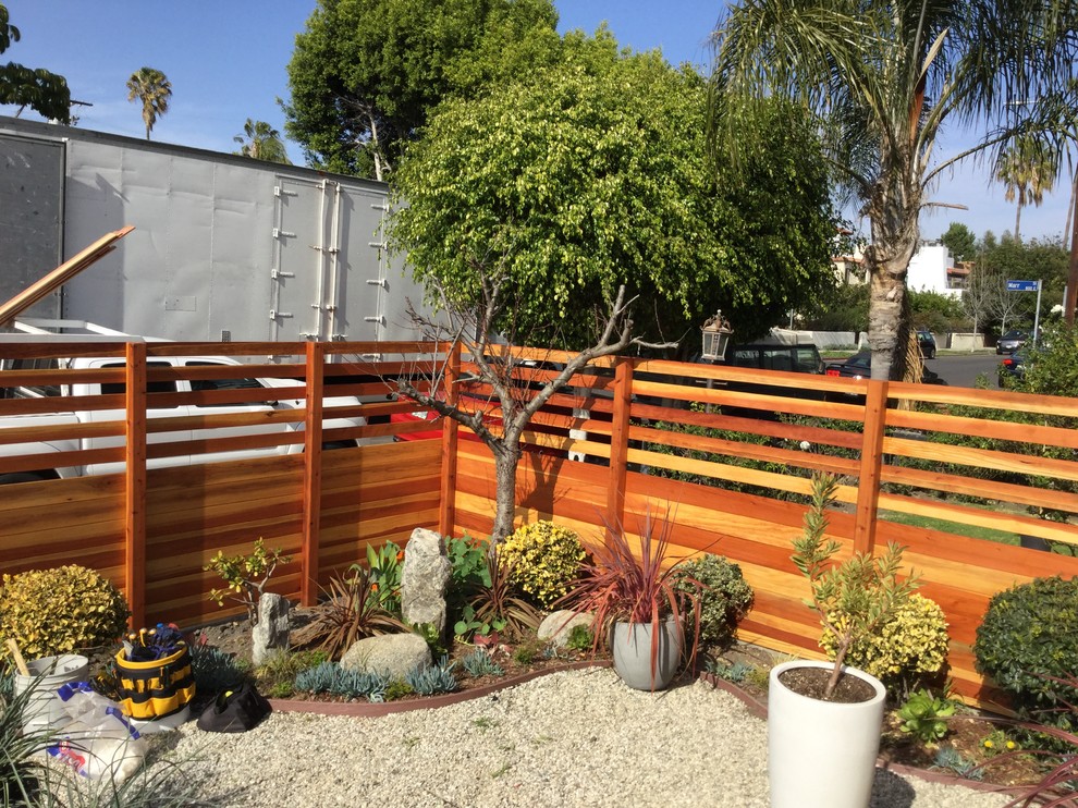 Modelo de jardín de estilo americano de tamaño medio en patio delantero con exposición total al sol y gravilla
