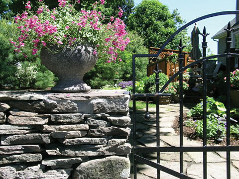 Diseño de jardín tradicional en patio lateral con exposición reducida al sol y adoquines de piedra natural