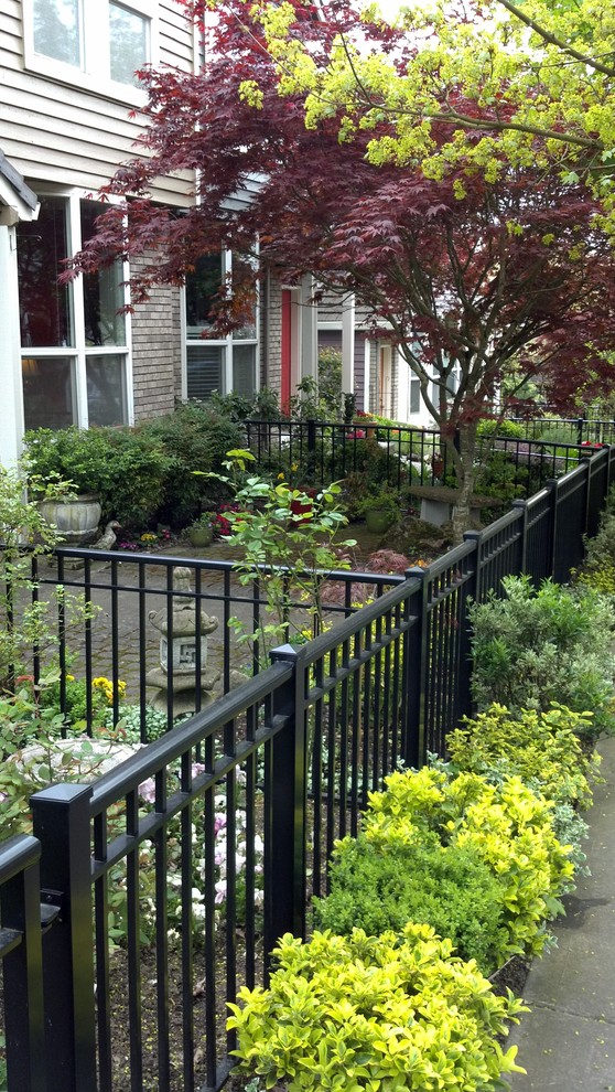 Imagen de jardín clásico pequeño en patio delantero con adoquines de hormigón