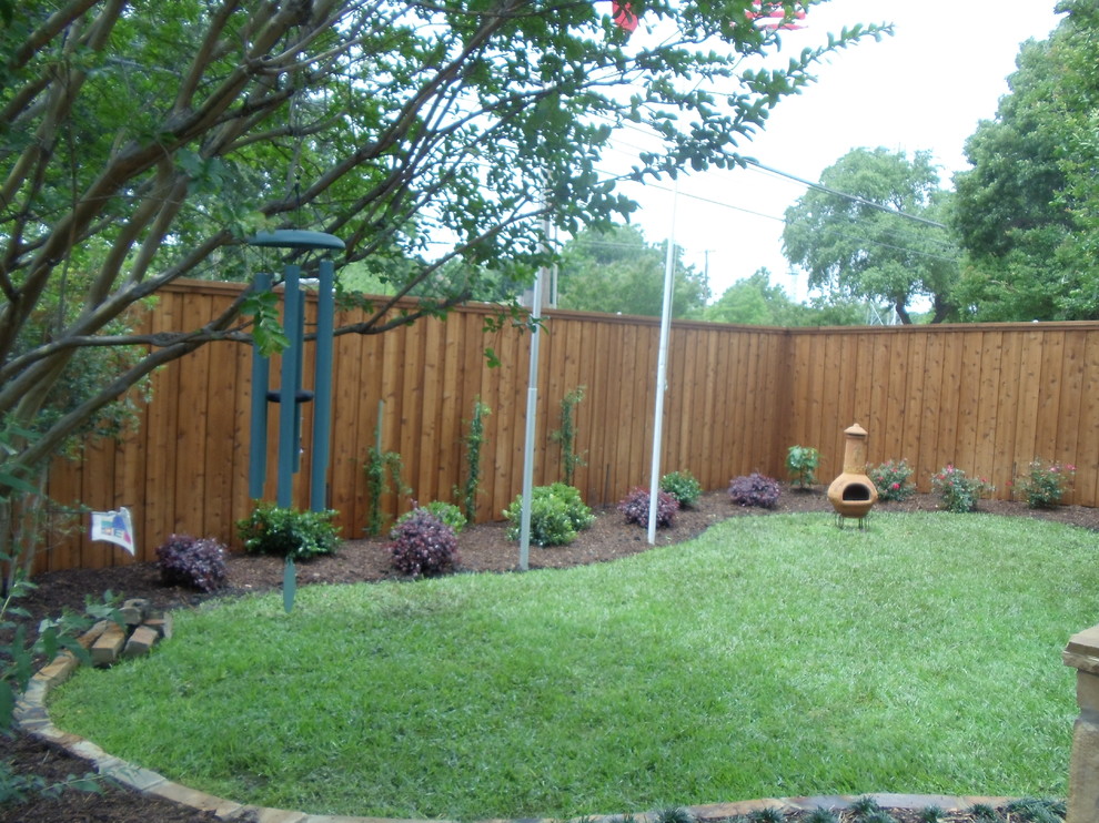 This is an example of a mid-sized traditional full sun backyard gravel landscaping in Dallas with a fire pit for spring.