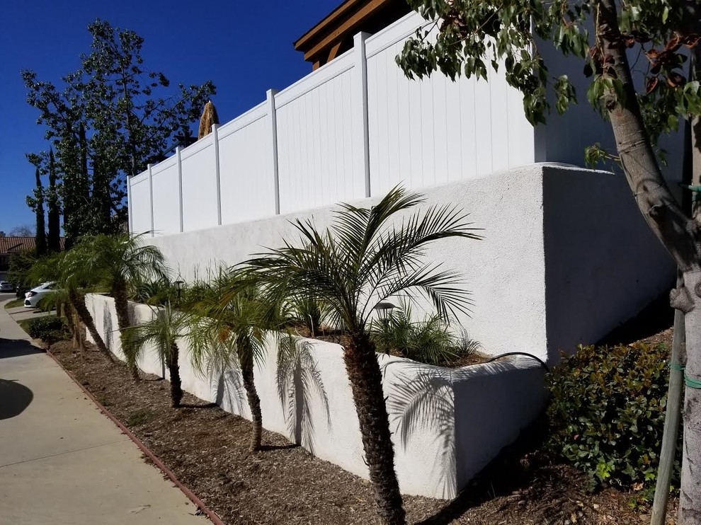 Inspiration for a mid-sized contemporary full sun front yard mulch retaining wall landscape in Los Angeles.