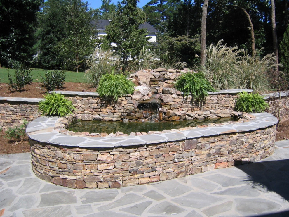 Immagine di un grande giardino country esposto in pieno sole dietro casa in estate con pavimentazioni in pietra naturale