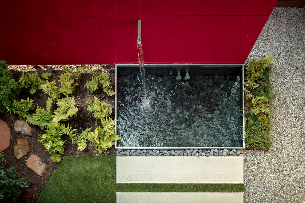 Ispirazione per un piccolo giardino minimalista in ombra dietro casa con fontane e pavimentazioni in cemento