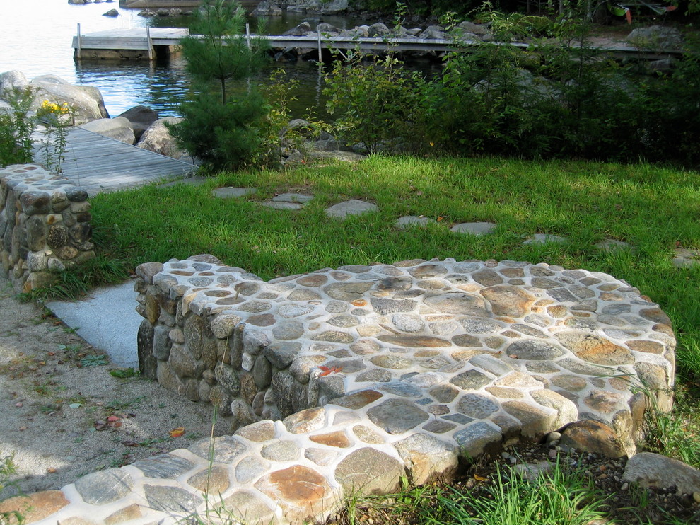Design ideas for a medium sized classic back garden in Raleigh with a retaining wall and natural stone paving.