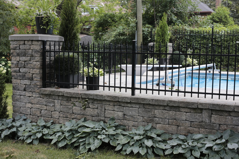 Пример оригинального дизайна: большой участок и сад на заднем дворе в стиле модернизм с подпорной стенкой и мощением тротуарной плиткой