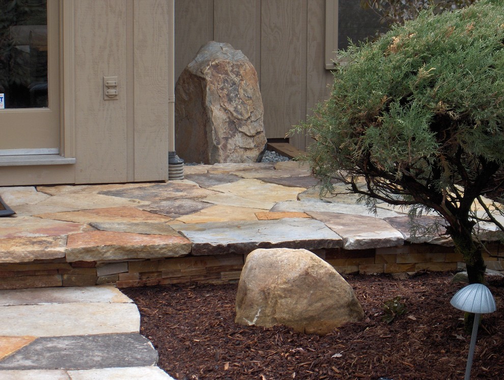 Ejemplo de jardín tradicional renovado de tamaño medio en patio delantero con adoquines de piedra natural
