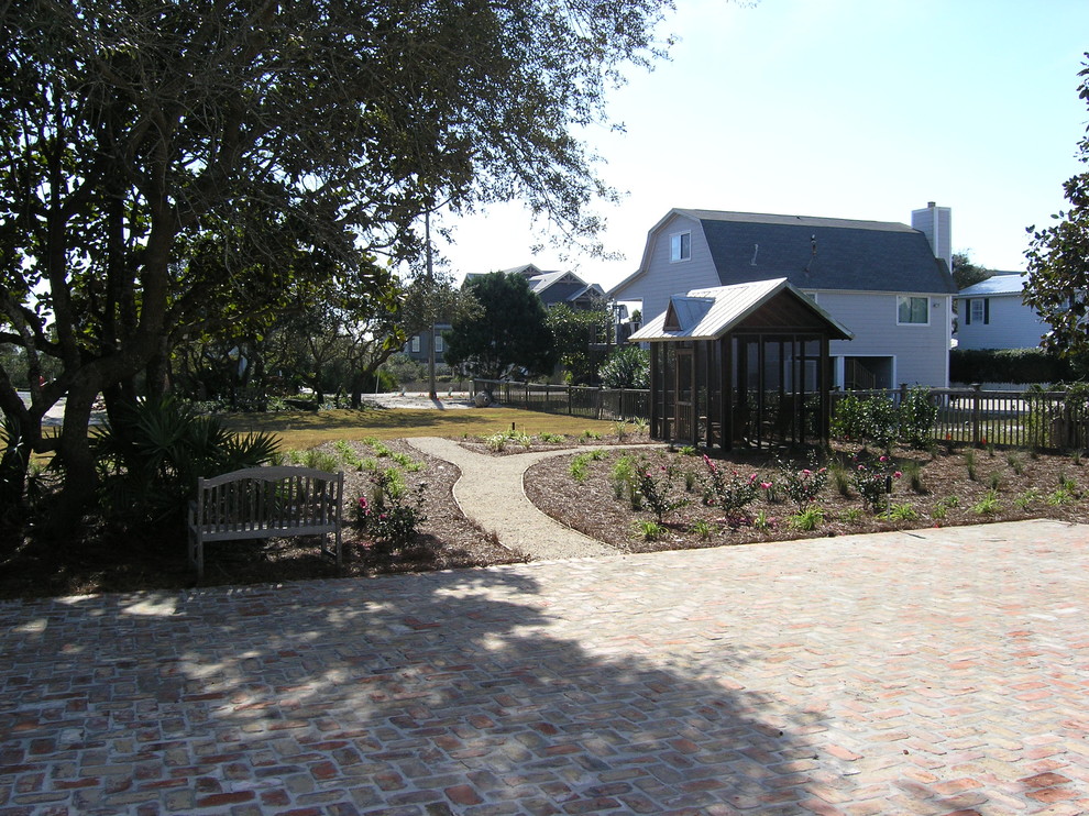 Exempel på en liten amerikansk trädgård i full sol framför huset, med en trädgårdsgång och marksten i tegel