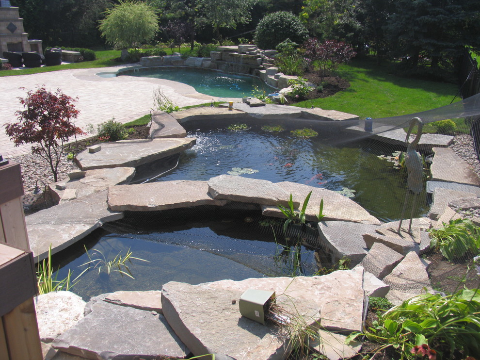 Esempio di un giardino american style esposto in pieno sole di medie dimensioni e dietro casa con pavimentazioni in pietra naturale