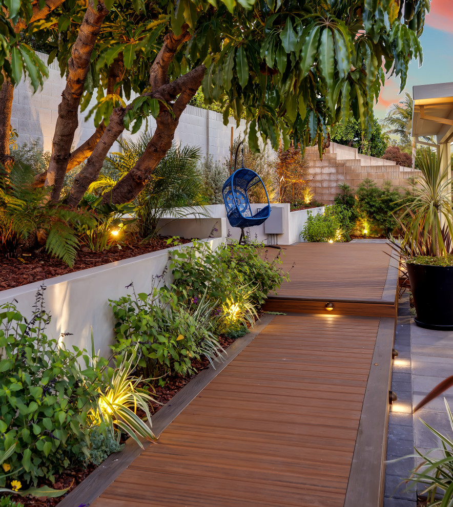 На фото: солнечный регулярный сад среднего размера на заднем дворе в современном стиле с хорошей освещенностью и мощением тротуарной плиткой