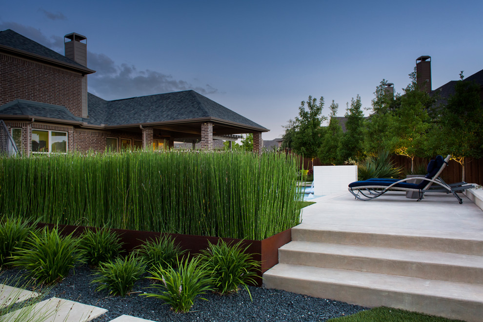 Großer Stilmix Garten hinter dem Haus mit Wasserspiel, Betonboden und direkter Sonneneinstrahlung in Dallas