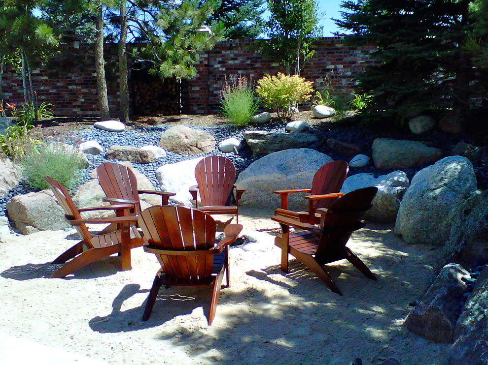 Design ideas for a mid-sized traditional partial sun backyard gravel landscaping in Denver with a fire pit.