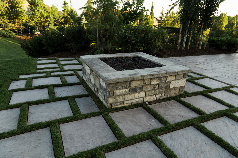 Idee per un grande giardino american style dietro casa con un focolare e pavimentazioni in cemento