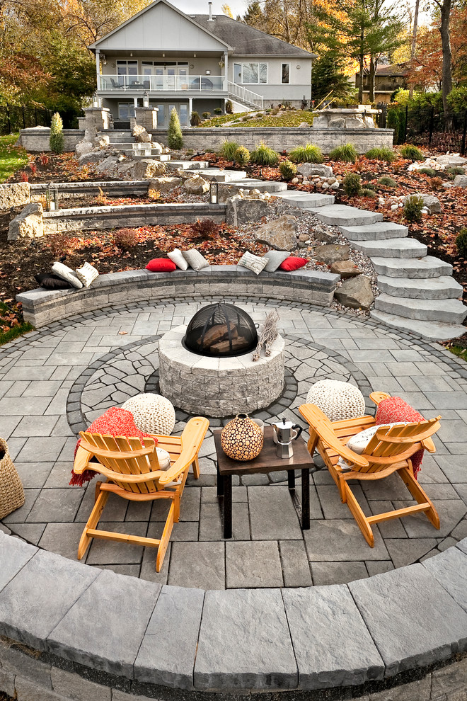 Diseño de patio tradicional renovado grande en patio trasero con brasero y adoquines de piedra natural