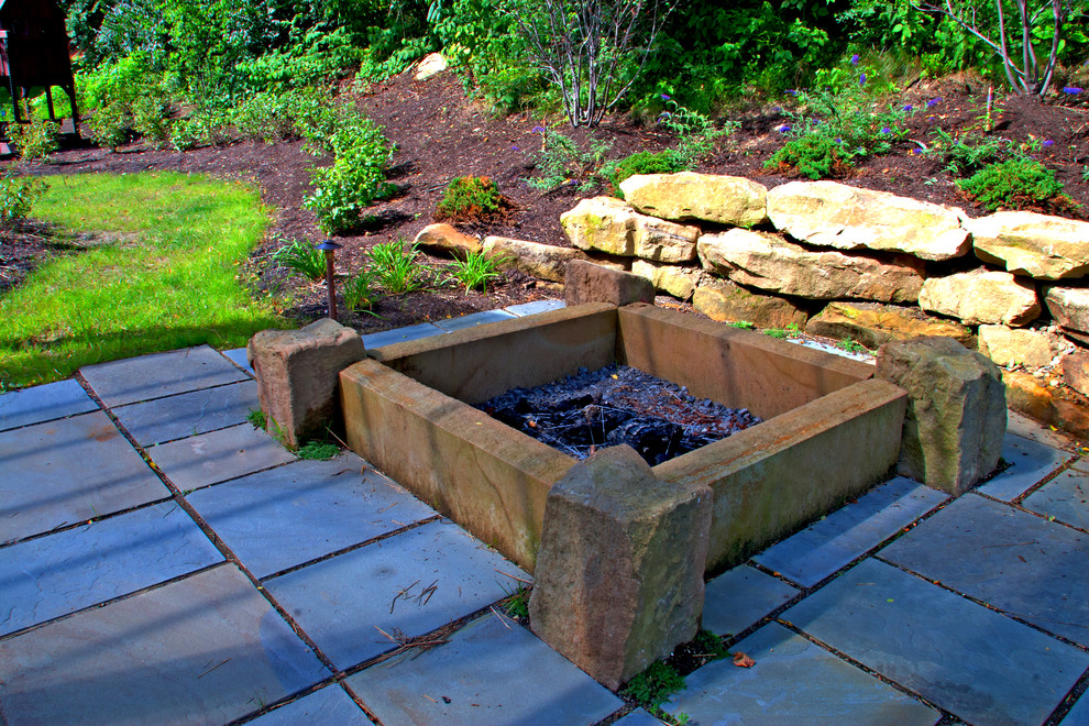 Photo of a small contemporary partial sun backyard stone formal garden in Other with a fire pit for summer.