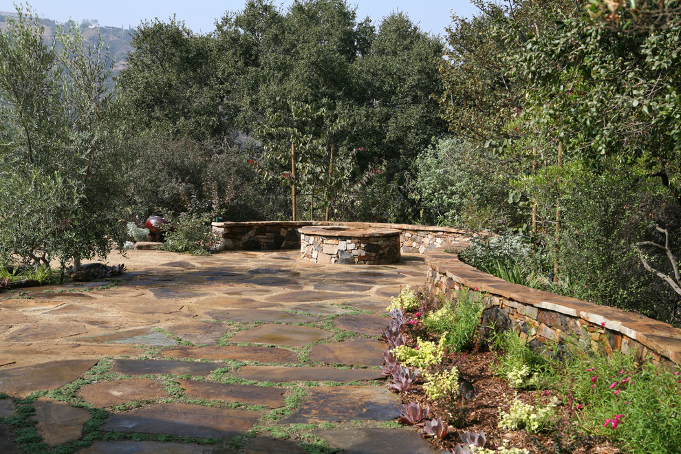 Immagine di un grande giardino moderno esposto in pieno sole dietro casa con un focolare e pavimentazioni in pietra naturale