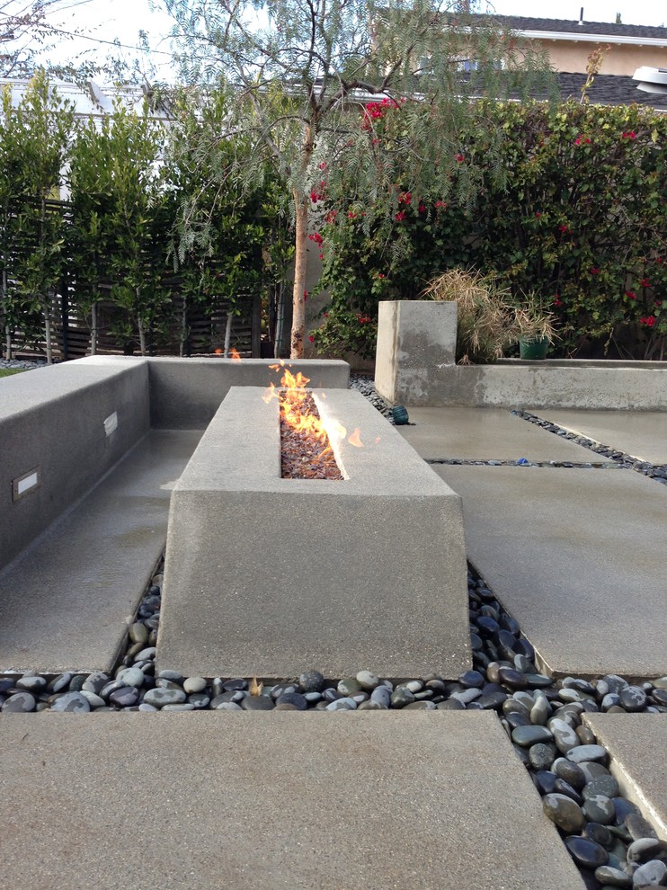 Halbschattiger, Mittelgroßer Moderner Garten hinter dem Haus mit Feuerstelle und Betonboden in Los Angeles