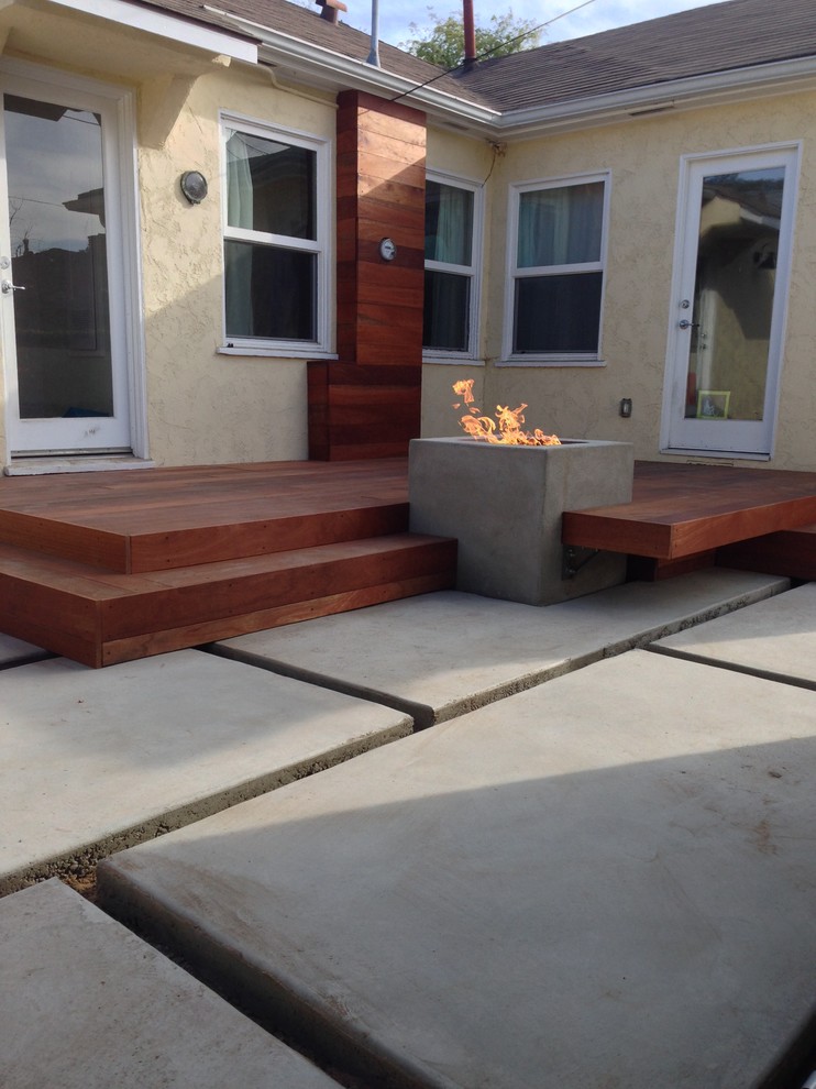 Photo of a mid-sized contemporary partial sun backyard landscaping in Los Angeles with a fire pit and decking.