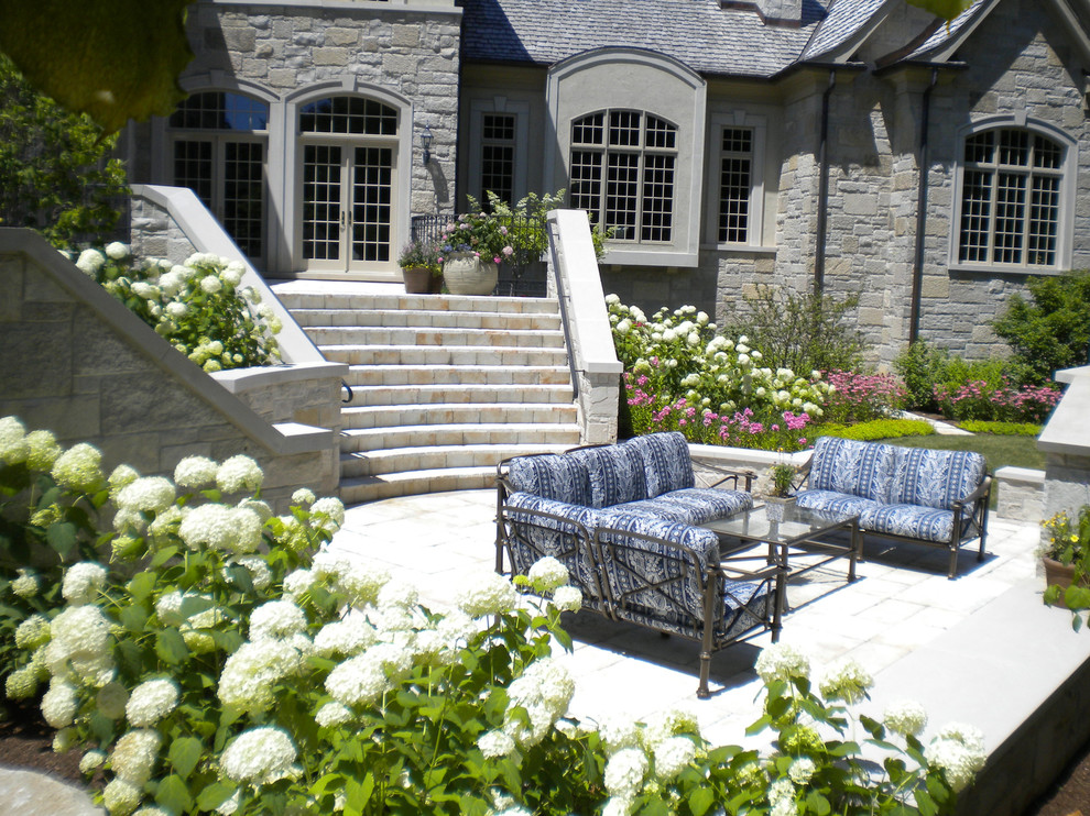 На фото: большой осенний участок и сад на заднем дворе в классическом стиле с местом для костра, полуденной тенью и покрытием из каменной брусчатки с