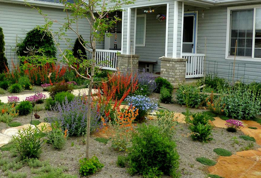 Modelo de camino de jardín de secano bohemio de tamaño medio en primavera en patio delantero con exposición total al sol y adoquines de piedra natural