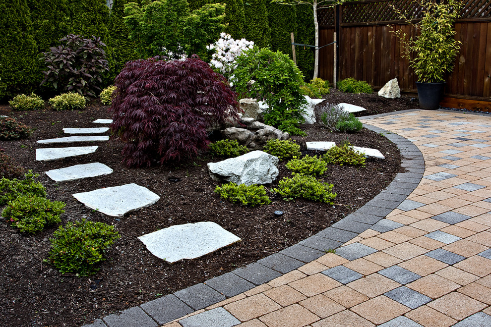 Medium sized contemporary partial sun garden in Other with natural stone paving.