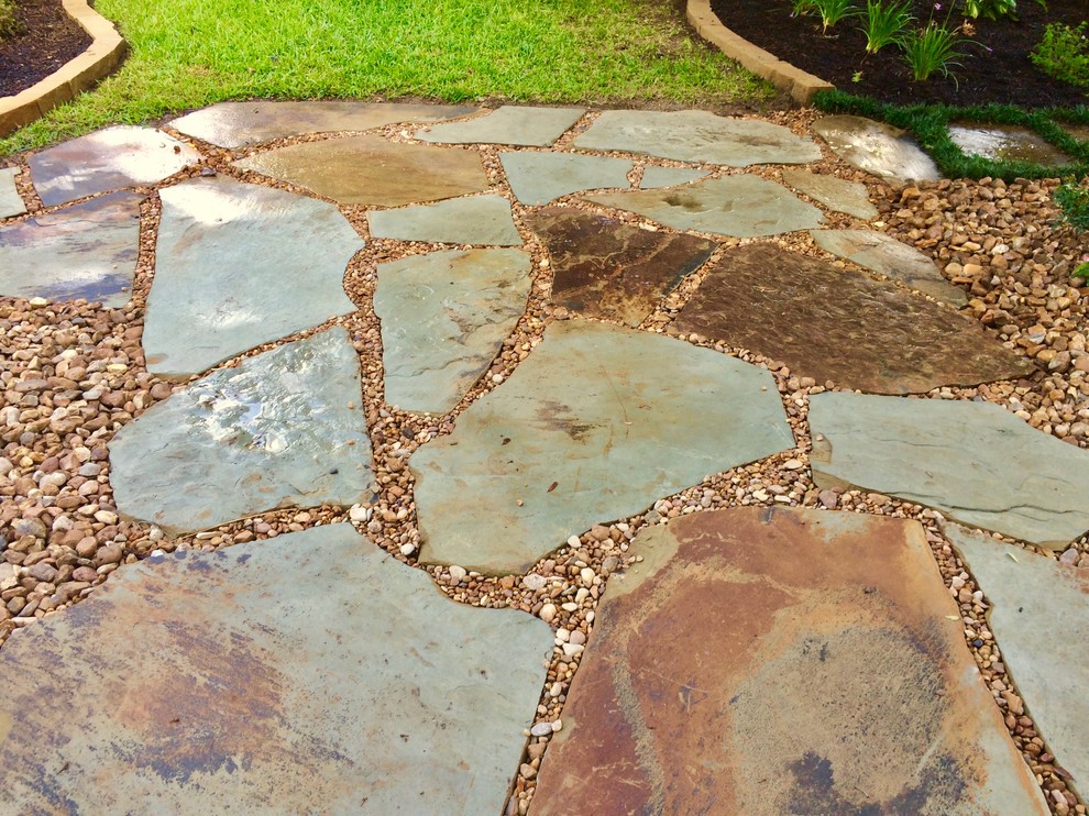 Inspiration for a mid-sized rustic shade front yard stone landscaping in Austin.