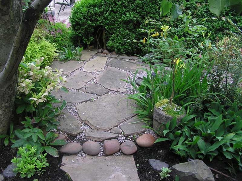 Diseño de jardín actual pequeño en patio trasero con exposición total al sol y adoquines de piedra natural