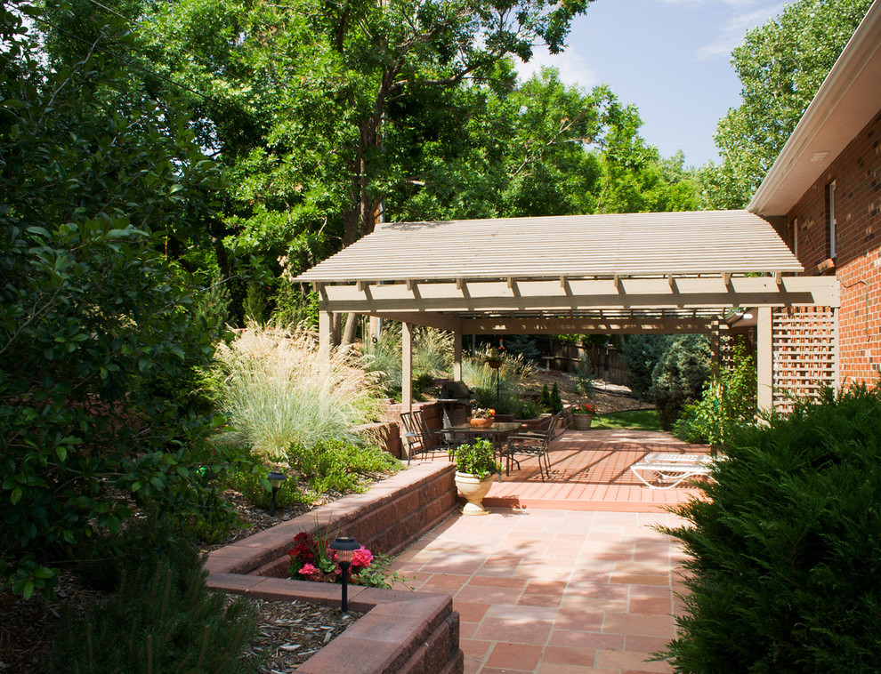 Пример оригинального дизайна: большой участок и сад на заднем дворе в современном стиле с подпорной стенкой, полуденной тенью и покрытием из каменной брусчатки