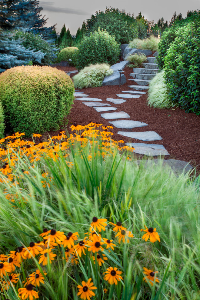 Esempio di un ampio giardino country esposto in pieno sole dietro casa in estate con un ingresso o sentiero e pavimentazioni in pietra naturale