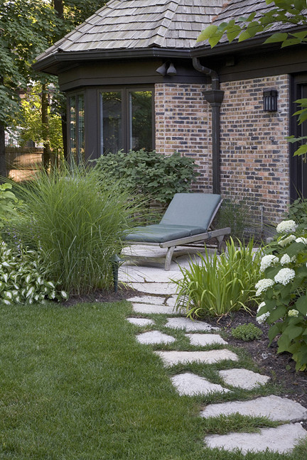 Diseño de jardín tradicional de tamaño medio en verano en patio trasero con exposición parcial al sol y adoquines de piedra natural