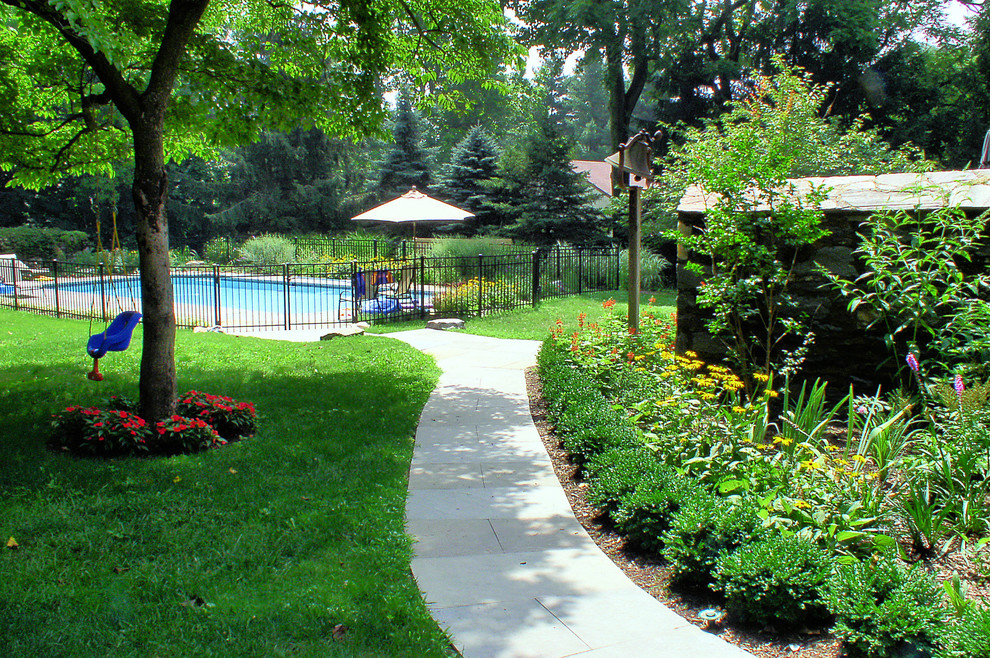 Imagen de camino de jardín actual grande en patio trasero con adoquines de piedra natural, jardín francés y exposición reducida al sol