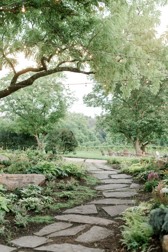 Immagine di un ampio giardino formale country esposto a mezz'ombra nel cortile laterale in estate con un ingresso o sentiero e pavimentazioni in pietra naturale