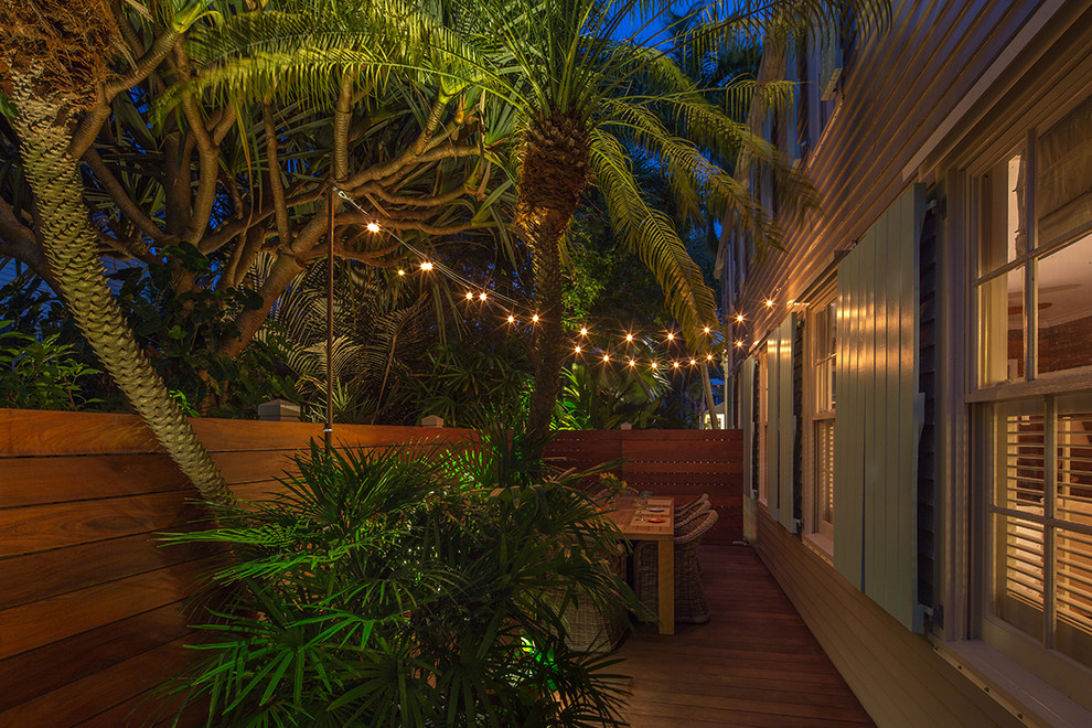 Idéer för att renovera en liten tropisk trädgård i delvis sol längs med huset, med trädäck