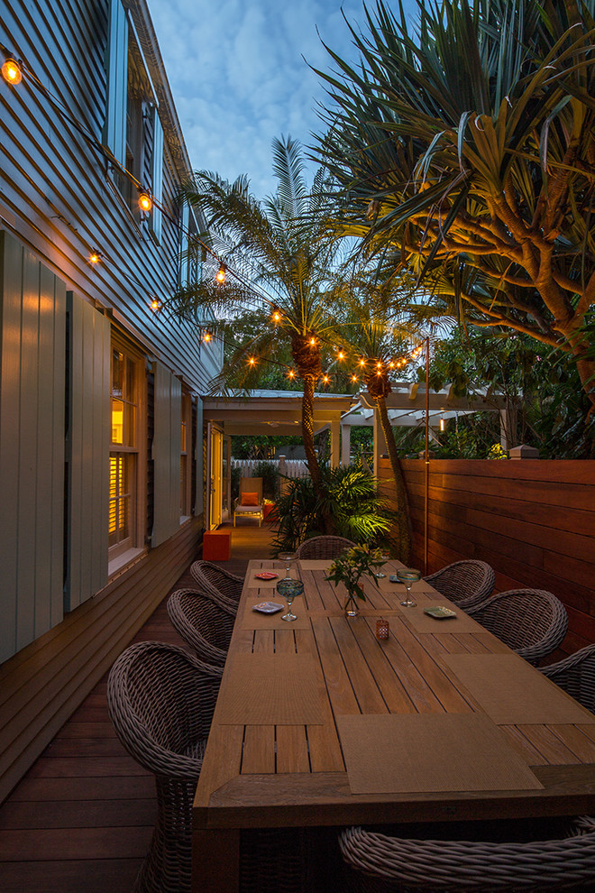 Inspiration för en liten tropisk trädgård i delvis sol längs med huset, med trädäck